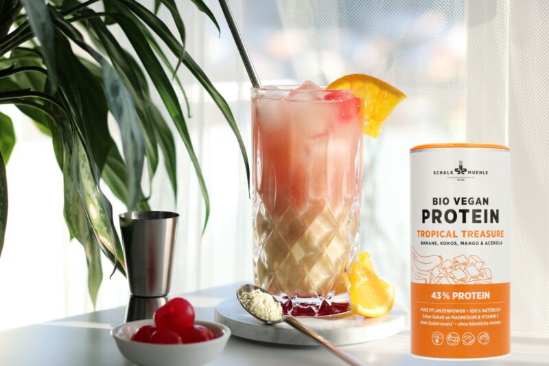 Schalk on the Beach dekoriert, rechts Tropical Treasure Protein, links ragt eine Pflanze ins Bild die tropische Gefühle weckt